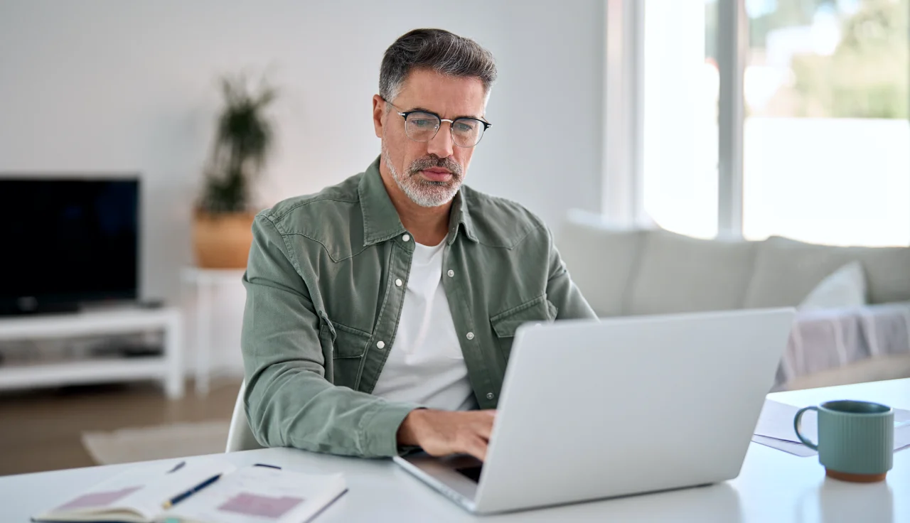 A man using a laptop while sitting at a desk