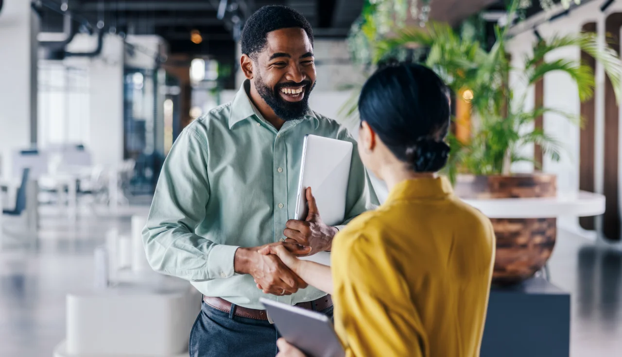 A man shaking hands with his female colleague